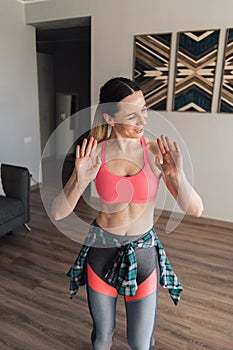 Smiling woman dancing in the middle of the living room enjoying herself and life