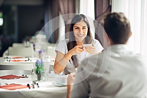 Smiling woman on a date in a restaurant,having a conversation over a meal in hotel.Positive emotions,love,affection