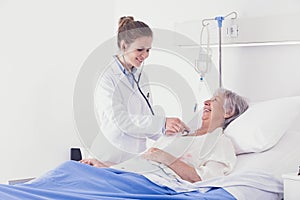 Smiling woman doctor examining an elderly lady