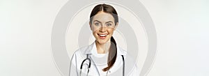 Smiling woman doctor, physician at appointment, looking happy and confident, wearing white coat and stethoscope