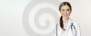 Smiling woman doctor, physician at appointment, looking happy and confident, wearing white coat and stethoscope