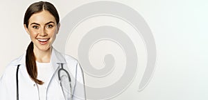 Smiling woman doctor, physician at appointment, looking happy and confident, wearing white coat and stethoscope