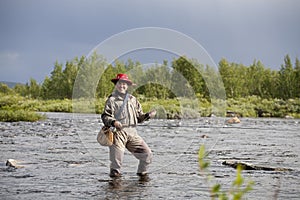 Smiling woman does fly fishing