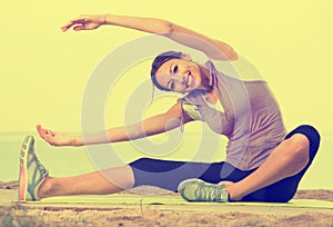 Smiling woman doing workout on sea beach