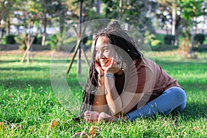 Smiling woman is doing yoga exercise outside in a park. Concept of healthy lifestyle