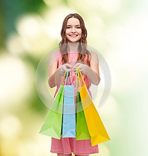 Smiling woman in dress with many shopping bags