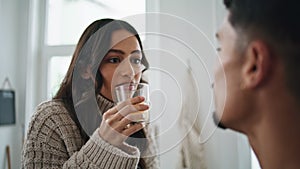 Smiling woman drinking glass of juice at home close up. Lady laughing of jokes