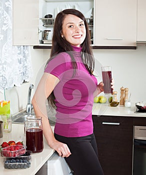 Smiling woman drinking red fruit-drink or juice