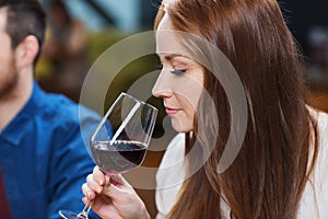 Smiling woman drinking red wine at restaurant