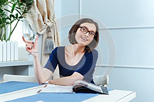 Smiling woman drinking water and waiting for waitress in cafe