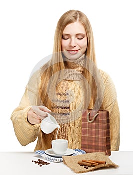 Smiling woman drinks coffee with milk and cinnamon