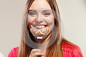 Smiling woman eating cake.
