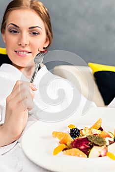 Smiling woman eating healthy food