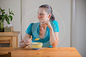 Smiling woman eating kitchari for a breakfast.