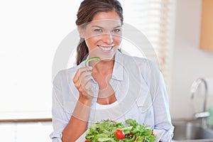 Smiling woman eating a salad