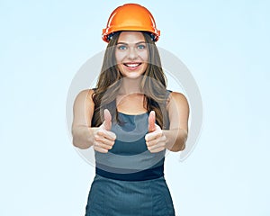 Smiling woman egineer wearing protect helmet show thumbs up. photo
