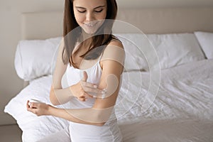 Smiling woman engaged in everyday skincare procedures after wake up