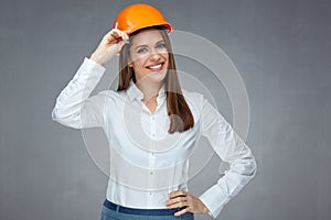 Smiling woman engineer builder worker touching her protect helmet.