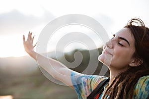 Smiling woman enjoy the morning and raise arm