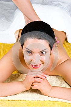 Smiling woman enjoying a back massage at spa
