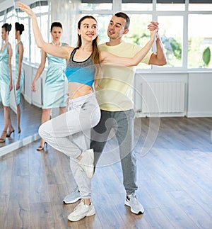 Smiling woman enjoying merengue with man in latin dance class