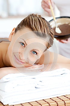 Smiling woman enjoying a mud treatment