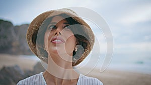Smiling woman enjoying seashore in straw hat closeup. Inspired travel girl rest
