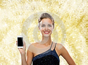 Smiling woman in evening dress with smartphone