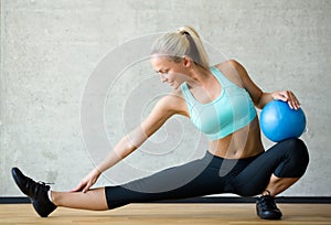 Smiling woman with exercise ball in gym