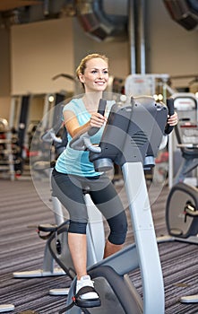 Smiling woman exercising on exercise bike in gym