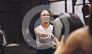 Smiling woman exercising with a partner using a medicine ball