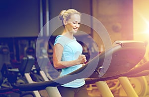 Smiling woman exercising on treadmill in gym