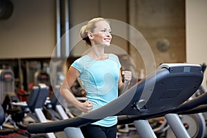 Smiling woman exercising on treadmill in gym