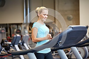 Smiling woman exercising on treadmill in gym