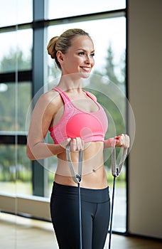 Smiling woman with expander in gym