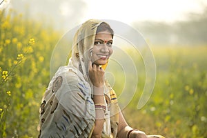 Smiling woman farmer in rapeseed agricultural field