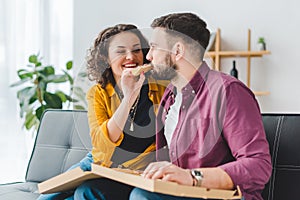 Smiling woman feeding her boyfriend