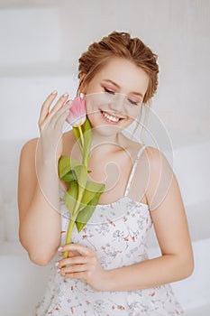 Smiling woman feels joy and happiness, holds a yellow tulip.