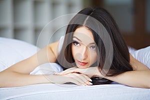 Smiling Woman With Fit Body And Beautiful Legs On White Bed