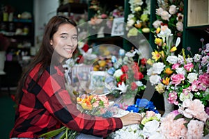 Smiling woman florist small business flower shop owner and Young florist examining flowers at the shop