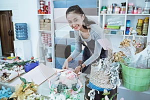 smiling woman florist working in flower shop make order flannel flower