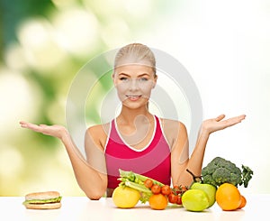 Smiling woman with fruits and hamburger