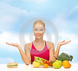 Smiling woman with fruits and hamburger