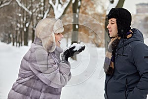 Smiling woman in fur coat and hat going to blow photo