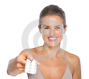 Smiling woman giving blistering package of pills