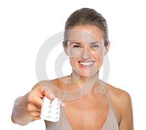 Smiling woman giving blistering package of pills photo