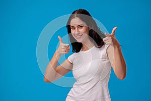 Smiling woman giving thumbs up on blue background