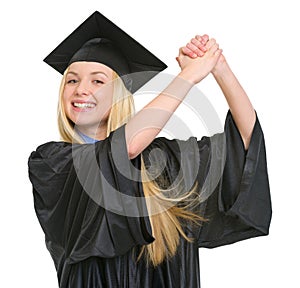 Smiling woman in graduation gown rejoicing success