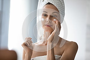 Smiling woman grooming herself after showering in bathroom.