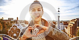 Smiling woman at Guell Park showing heart shaped hands
